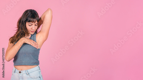 Woman doing a Breast Self-Exam over pink background. Copy space