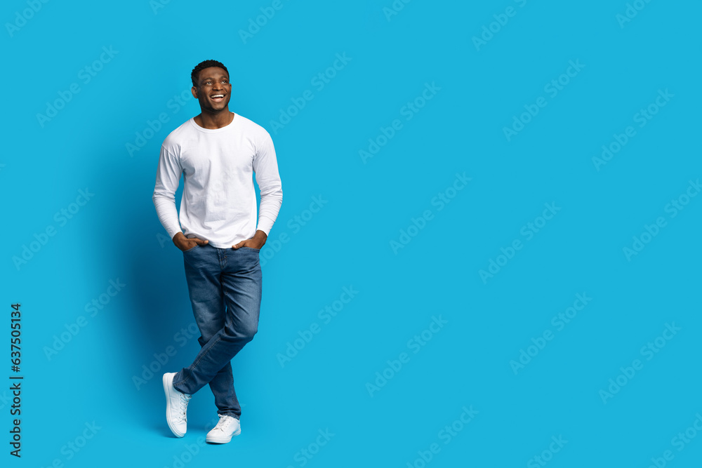 Cheerful handsome black guy looking at copy space, full length Cheerful handsome black guy looking at copy space, full length