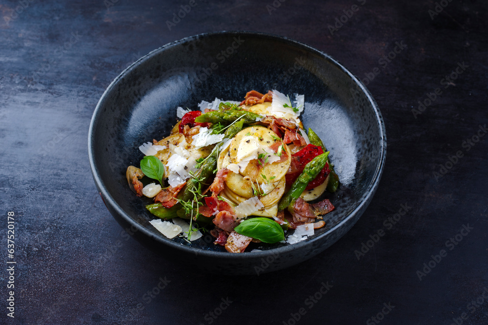 Green glazed asparagus with fried prosciutto ham, croxetti pasta and parmesan cheese served as close-up on a design plate with text space Green glazed asparagus with fried prosciutto ham, croxetti pasta and parmesan cheese served as close-up on a design plate with text space