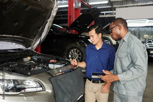 Man asking auto mechaninc to examine and fix his car photo