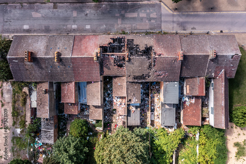 Aerial view directly above the damaged roof of derelict terraced houses after a house fire