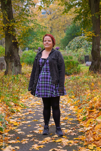 Portrait of woman standing in cemetery during autumn