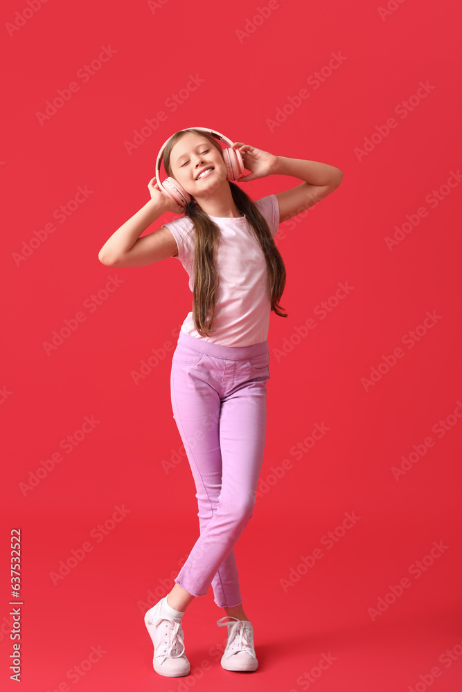 Little girl in headphones on red background Little girl in headphones on red background