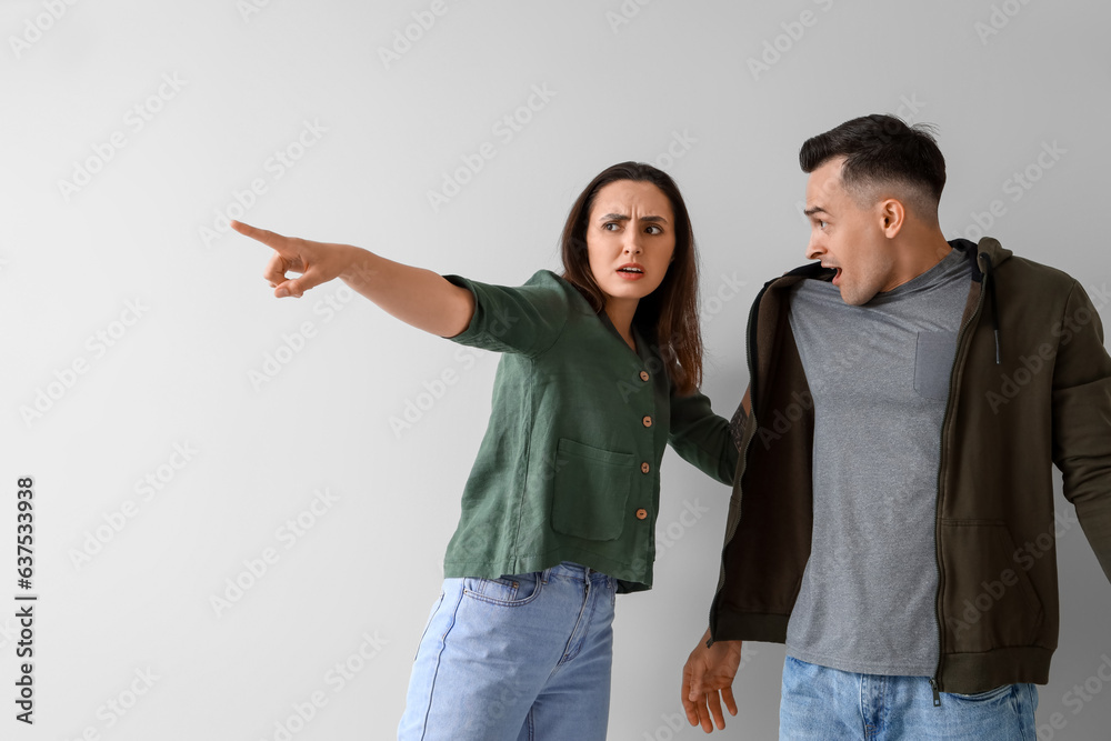 Young couple quarreling on light background Young couple quarreling on light background