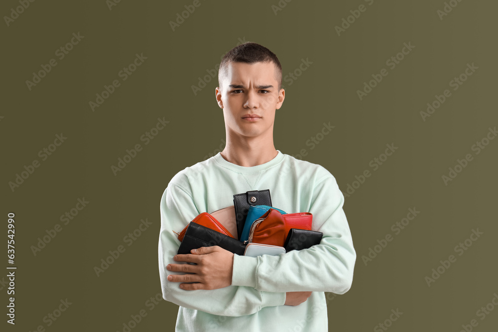 Upset young man with wallets on green background Upset young man with wallets on green background