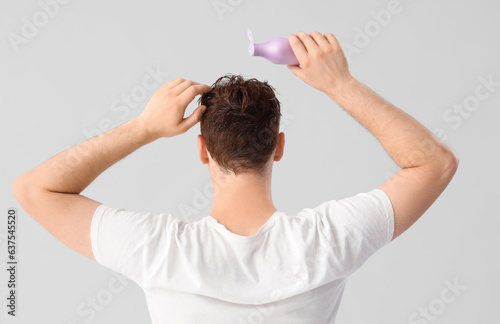 Young man applying shampoo ...