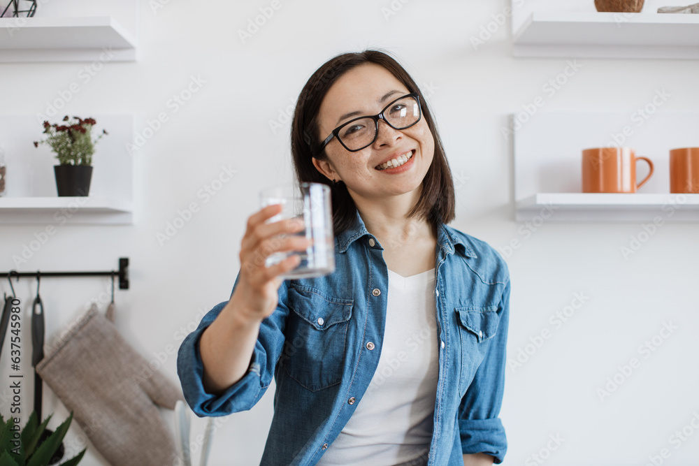 Tumbler glass with clean liquid reached out by asian woman Tumbler glass with clean liquid reached out by asian woman