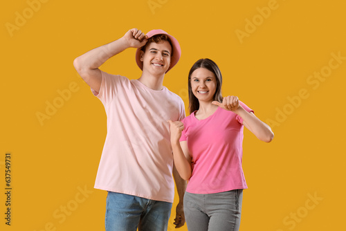 Young couple in t-shirts on yellow background