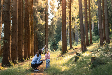 Mother child in the woods learning about nature 