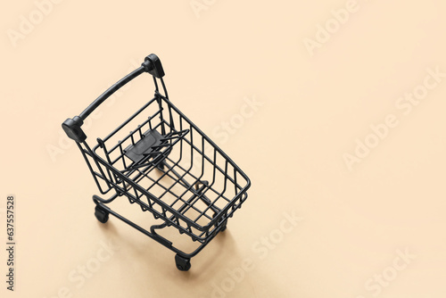 Small shopping cart on beige background