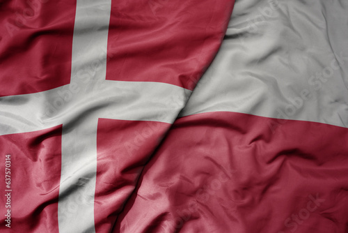 big waving national colorful flag of denmark and national flag of poland .