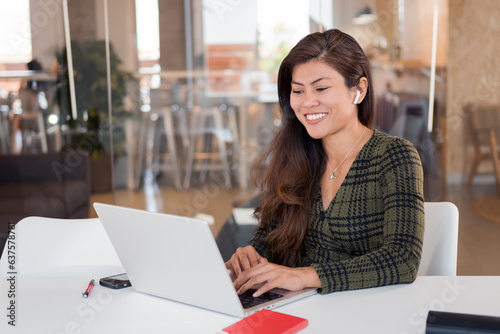 Cheerful young woman working on laptop
