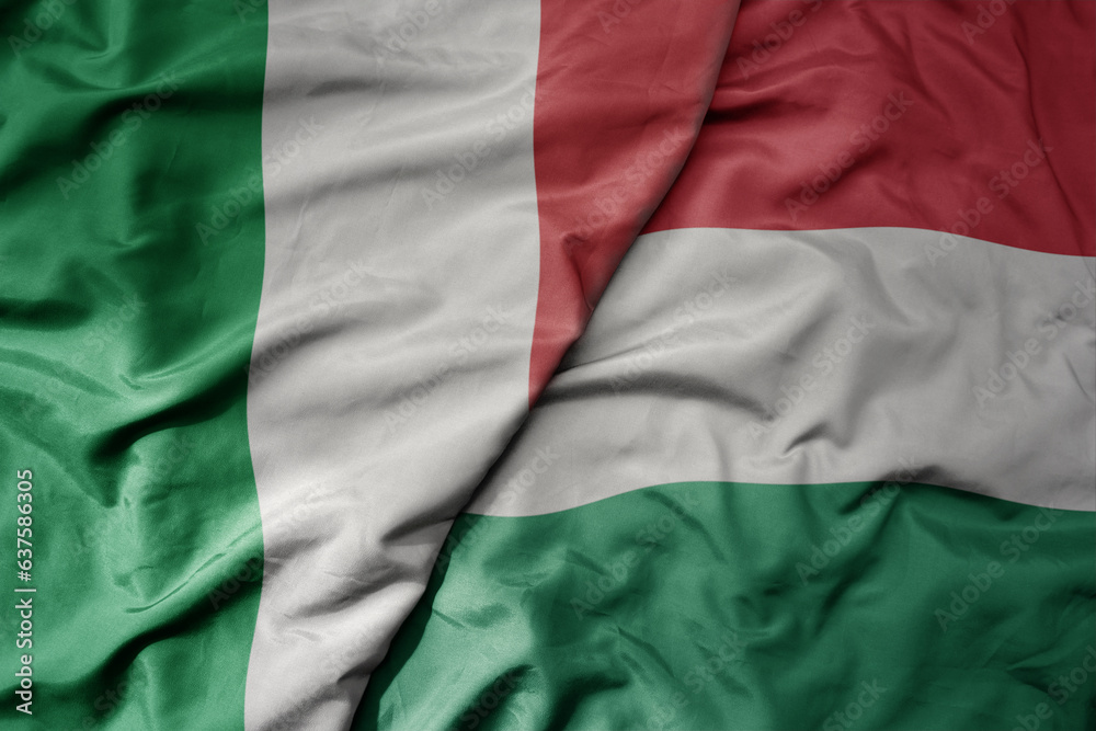 Obraz premium big waving national colorful flag of italy and national flag of hungary .