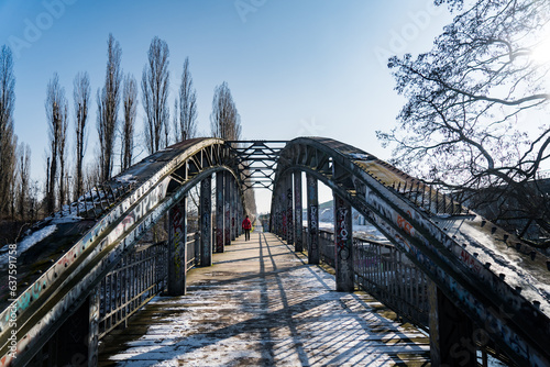 man walking on steel bridge in winter