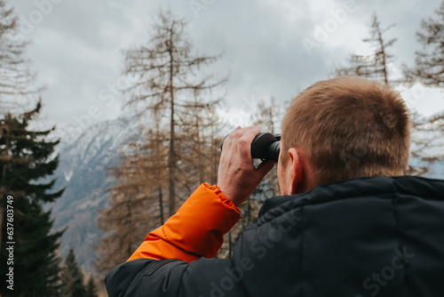 Man with binoculars.Viewing the mountains with binoculars.Hiking in the mountains in the spring season.walking in the mountains