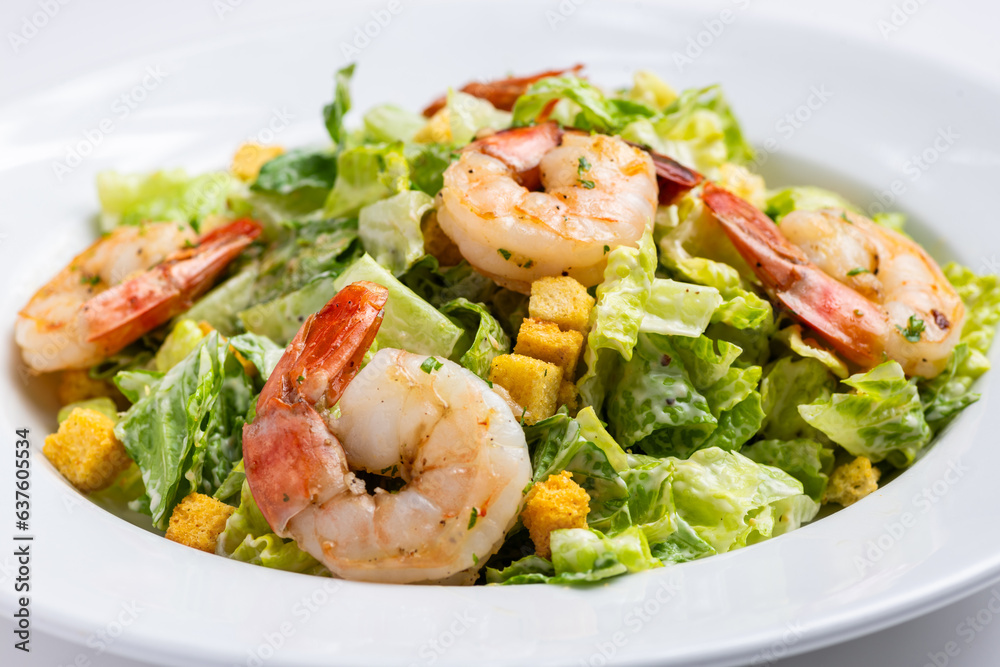 Close up classic Caesar Salad with grilled shrimps on white background