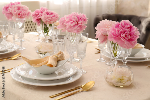 Stylish table setting with beautiful peonies and fabric napkins indoors