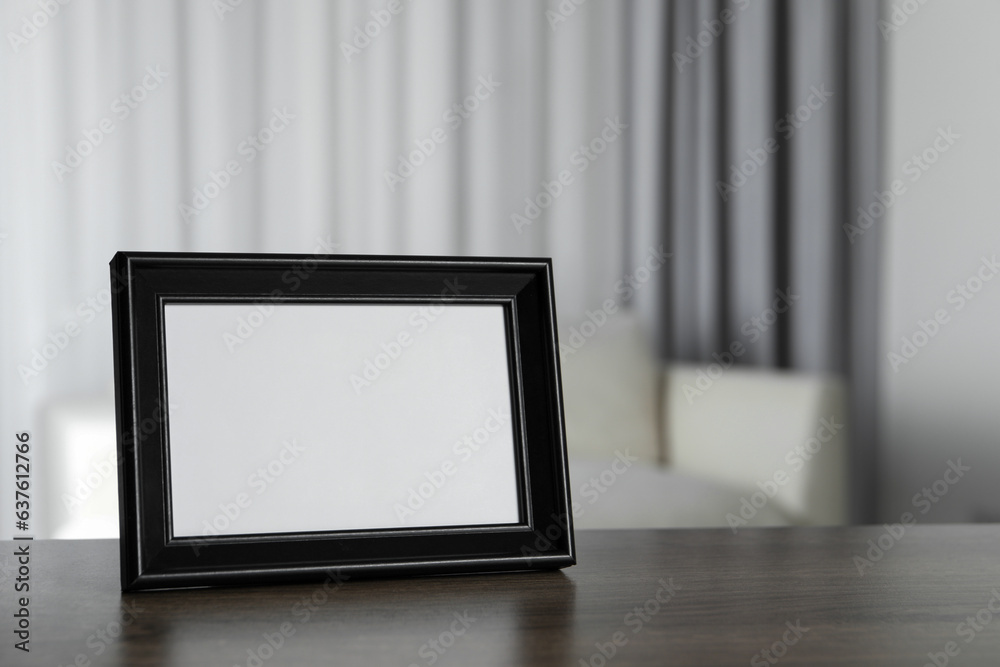 Empty square frame on wooden table indoors, space for text Empty square frame on wooden table indoors, space for text