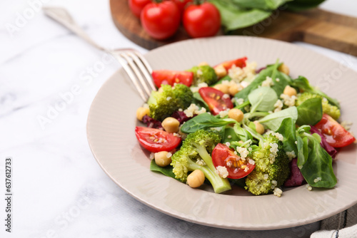 Healthy meal. Tasty salad with quinoa, chickpeas and vegetables served on white marble table, closeup