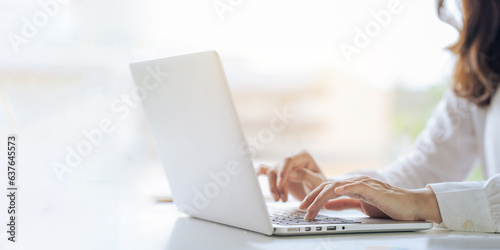 Closeup shot of hands using laptop and typing on keyboard  searching information