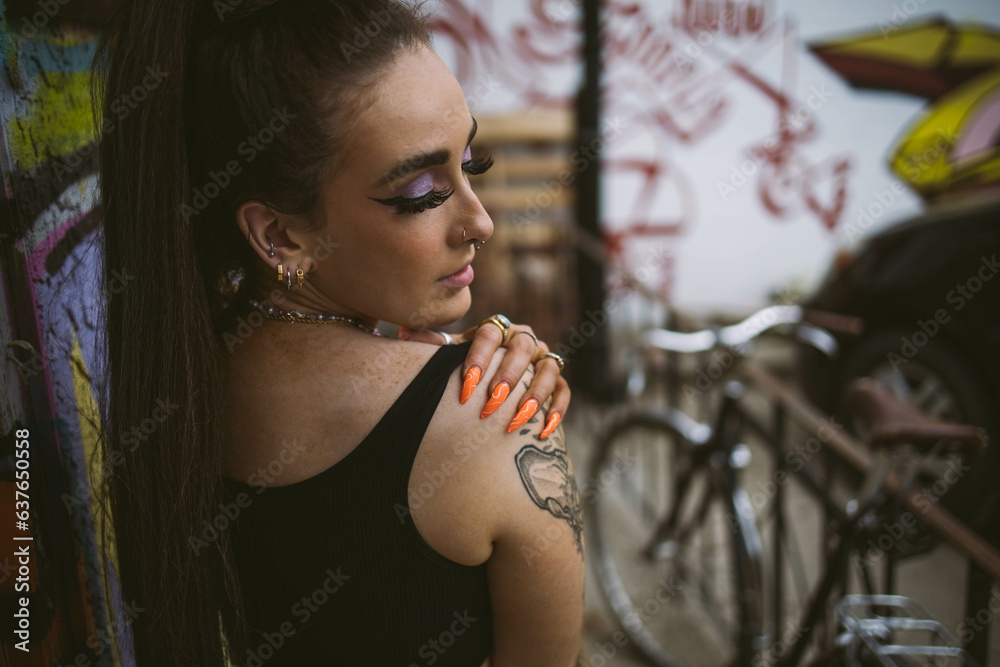 Young beautiful tattooed woman and graffiti street photography