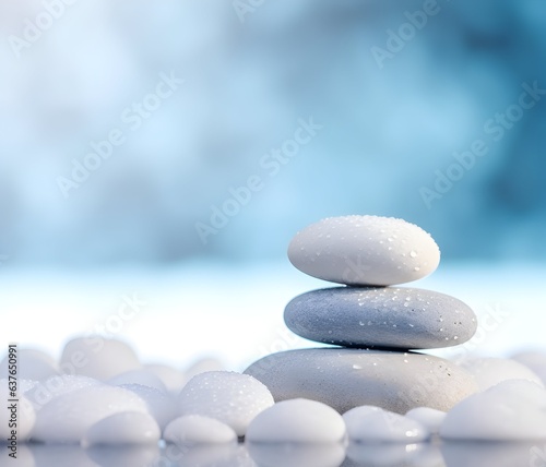 White and gray stones are stacked on a mirrored surface  surrounded by small translucent white pebbles. Zen and balance concept. 