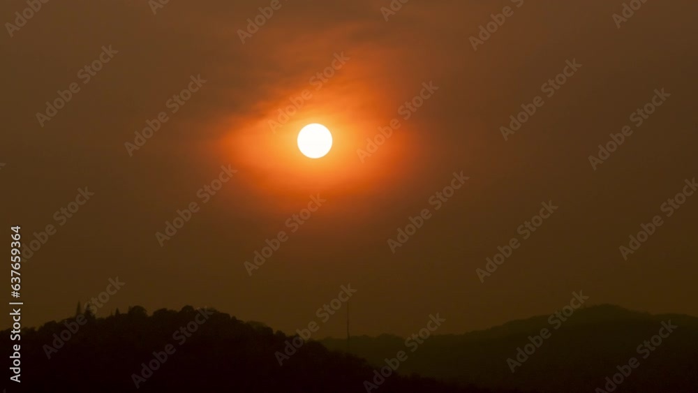 Time lapse of the sun setting over hills that are covered with clouds, in the style of smokey background. Time lapse of the sun setting over hills that are covered with clouds, in the style of smokey background.