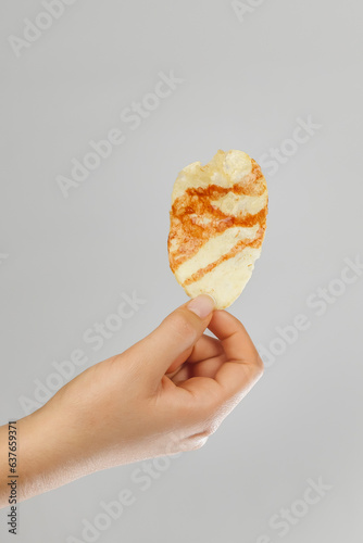 hands holding chips with hot sauce