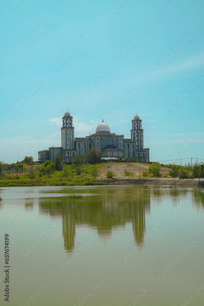 This magnificent building resembling a dome and a mosque in an empty field with an artificial lake above is the regional government office of Idi Rayeuk, East Aceh, Indonesia
