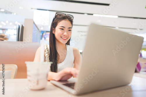 Beautiful woman freelance digital nomad job woman sitting indoors cafe with laptop