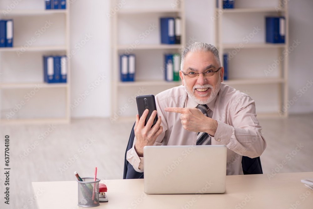 Old male employee working in the office Old male employee working in the office