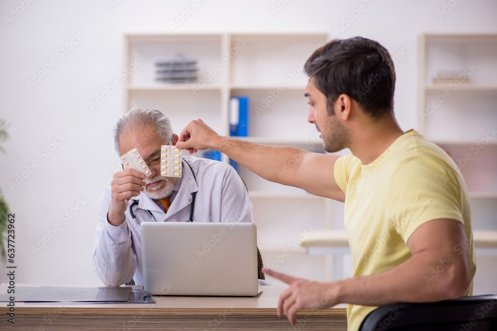 Young male patient visiting old male doctor Young male patient visiting old male doctor