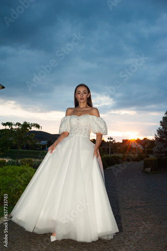 Beautiful bride woman in wedding dress on sunset outdoor