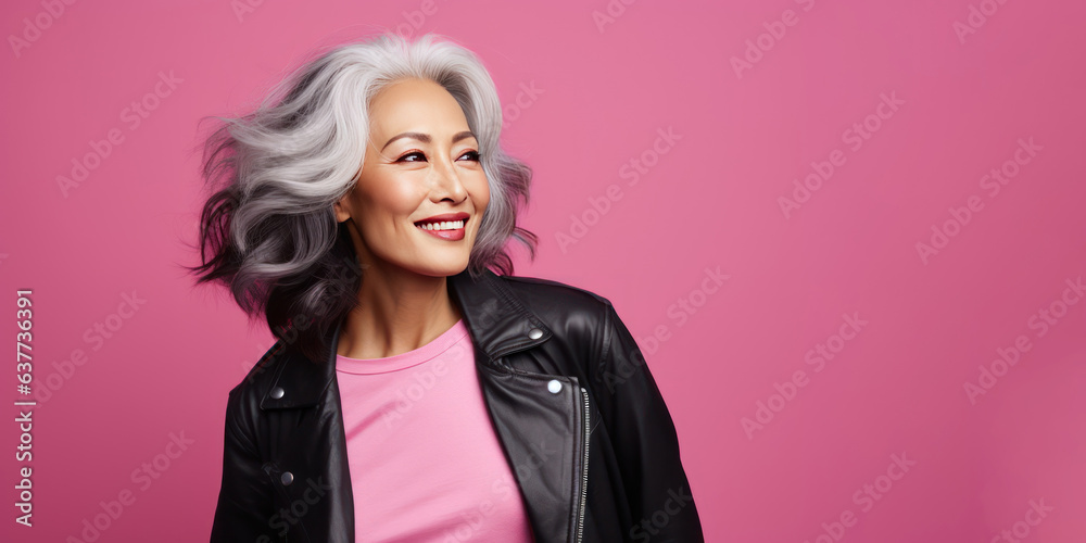 Portrait of a stylish sensual Asian woman in her 50s. Luxurious middle-aged woman with a short hairdo on pink background looking on copy space. Portrait of a stylish sensual Asian woman in her 50s. Luxurious middle-aged woman with a short hairdo on pink background looking on copy space.