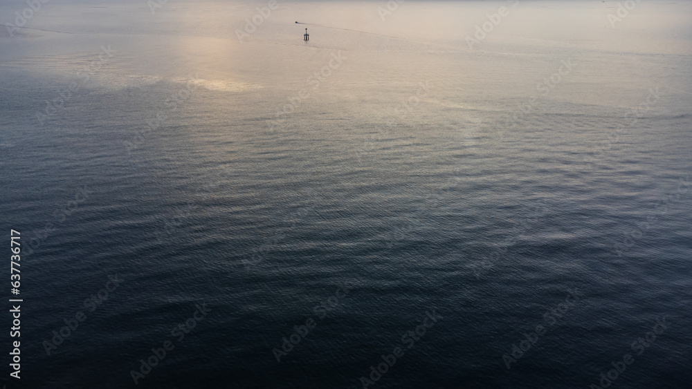 Calm sea with sunset sky and sun through the clouds over. Meditation ocean and sky background.