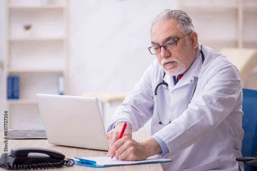 Old male doctor working in the clinic Old male doctor working in the clinic