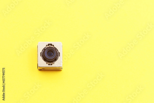 A miniature digital camera of a mobile phone on a yellow background photo