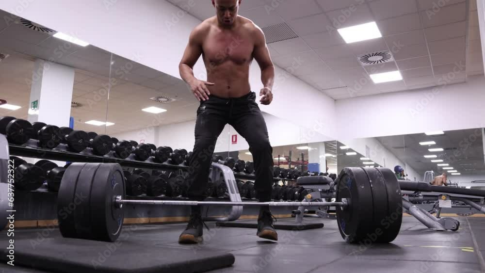 Low angle view of a man deadlifting in a gym Low angle view of a man deadlifting in a gym