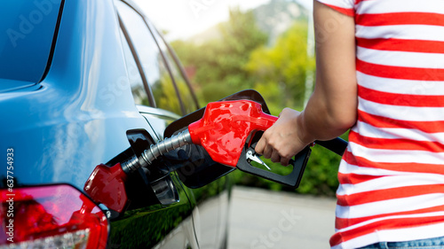 Woman hand refilling the car with fuel photo