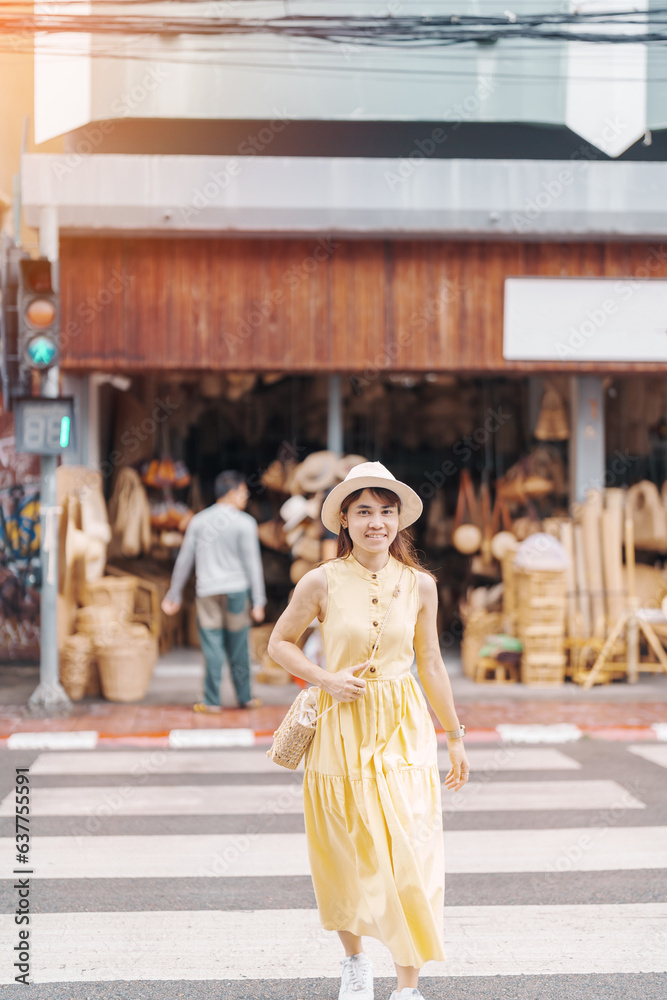 Young asian woman traveler in dress with hat traveling to wicker shop on Chang Moi Kao Road, Tourist visit at the old city in Chang Mai, Thailand. Asia Travel, Vacation and summer holiday concept