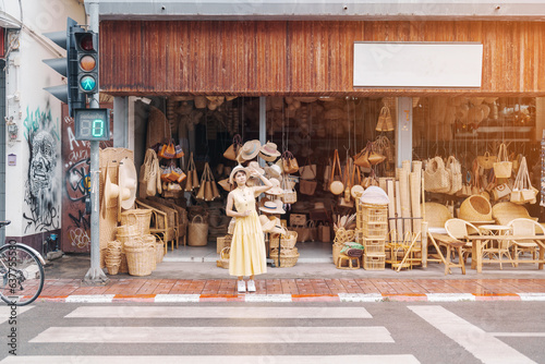 Fotografia Young asian woman traveler in dress with hat traveling to wicker shop on Chang Moi Kao Road, Tourist visit at the old city in Chang Mai, Thailand