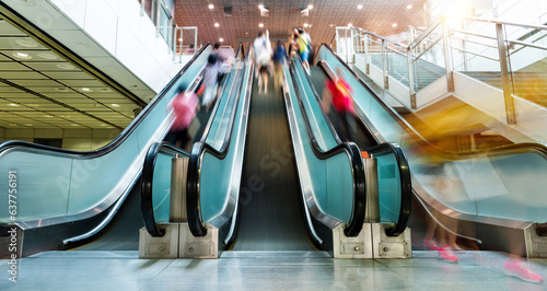 People rushing in the escalator lobby