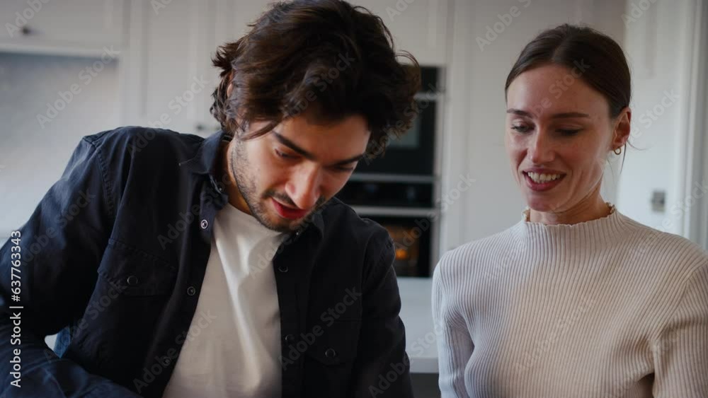 Close up of couple in kitchen at home serving fresh homemade pizza from the oven - shot in slow motion Close up of couple in kitchen at home serving fresh homemade pizza from the oven - shot in slow motion