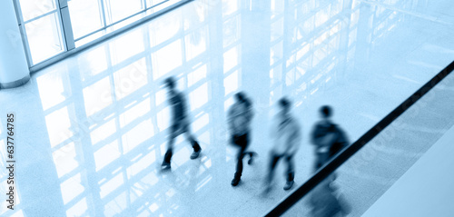 Group of business people walking in modern office building
