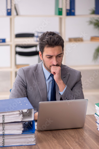 Young male employee and too much work in the office