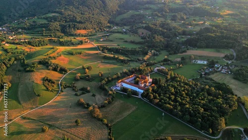 Stunning  4K drone footage of Cistercijanski Monastery Kostanjevica na Krki in golden sunset light. It is a medieval town embraced by the Krka River. Cinematic video captured during a sunny summer day photo