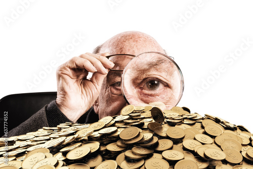 Elderly person looks his hoard with a magnifying glass