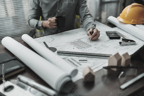 Engineering working with drawings inspection and Calculator, triangle ruler, safety glasses, compass, vernier caliper on Blueprint. Engineer, Architect, Industry and factory concept.