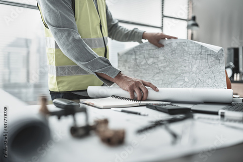 Architect, engineer planning and reading on city map and marking  a place to building. photo