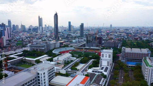 Chulalongkorn University Stadium With Skyscrapers At The Background In Pathumwan, Bangkok, Thailand. Aerial Shot  photo